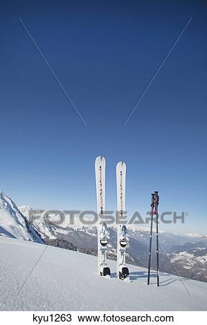 Skis and ski poles stuck in the snow View Large Photo Image Stock Image - Skis and ski poles stuck in the snow. Fotosearch