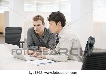 Two businessmen working in an office View Large Photo Image Stock Image - Two businessmen working in an office. Fotosearch