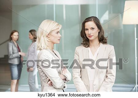 Two businesswomen standing together View Large Photo Image Picture - Two businesswomen standing together. Fotosearch