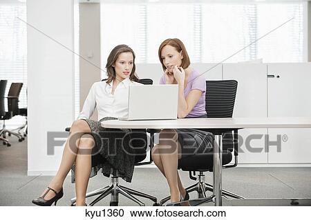 Two businesswomen working in an office View Large Photo Image Stock Image - Two businesswomen working in an office. Fotosearch