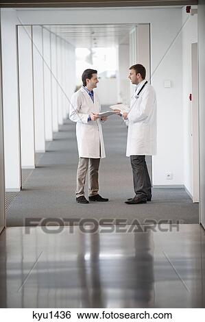 Two male doctors discussing View Large Photo Image Stock Photograph - Two male doctors discussing. Fotosearch