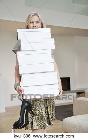Stock Photograph - Woman carrying shoe boxes. Fotosearch