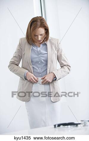 Woman getting dressed in an office View Large Photo Image Stock Photography - Woman getting dressed in an office. Fotosearch
