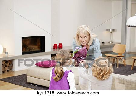 Woman giving a potted plant to her grandchildren View Large Photo Image Stock Photo - Woman giving a potted plant to her grandchildren. Fotosearch