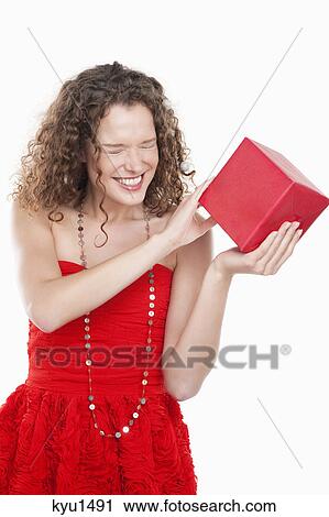 Stock Image - Woman holding a present and squinting eyes. Fotosearch