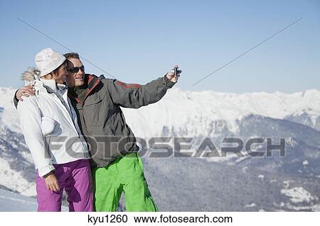 Young couple in ski wear taking self portrait View Large Photo Image Stock Image - Young couple in ski wear taking self portrait. Fotosearch