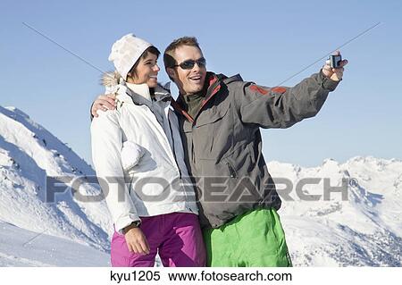 Young couple in ski wear taking self portrait View Large Photo Image Stock Photography - Young couple in ski wear taking self portrait. Fotosearch