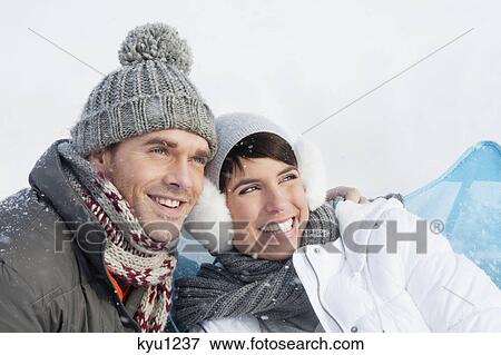 Stock Photo - Young couple in winter clothes embracing. Fotosearch