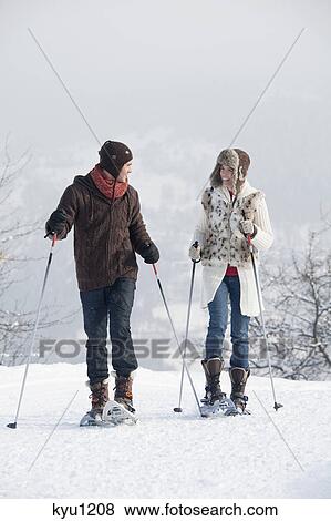 Young couple snowshoeing View Large Photo Image Stock Photo - Young couple snowshoeing. Fotosearch