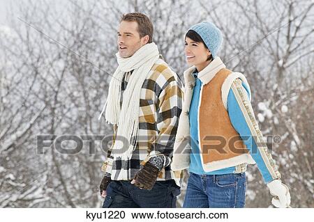 Young couple walking in snow View Large Photo Image Stock Image - Young couple walking in snow. Fotosearch