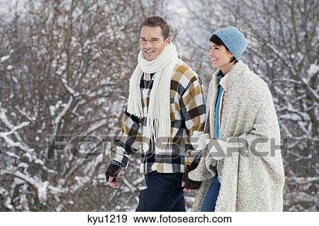Stock Photo - Young couple walking in snow. Fotosearch
