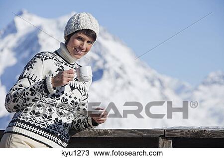 Young woman drinking coffee, mountains in background View Large Photo Image Stock Image - Young woman drinking coffee, mountains in background. Fotosearch