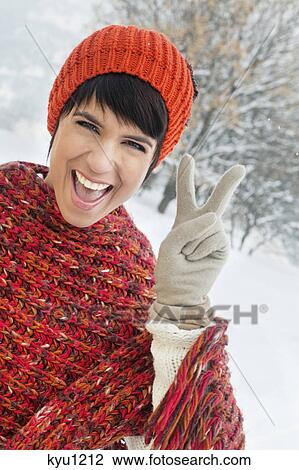 Young woman in winter clothes making peace sign View Large Photo Image Stock Image - Young woman in winter clothes making peace sign. Fotosearch