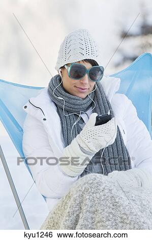 Young woman listening to MP3 player in snow View Large Photo Image Stock Photograph - Young woman listening to MP3 player in snow. Fotosearch