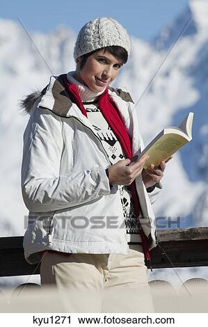 Young woman reading a book, enjoying winter sun, mountains in background View Large Photo Image Stock Image - Young woman reading a book, enjoying winter sun, mountains in background. Fotosearch