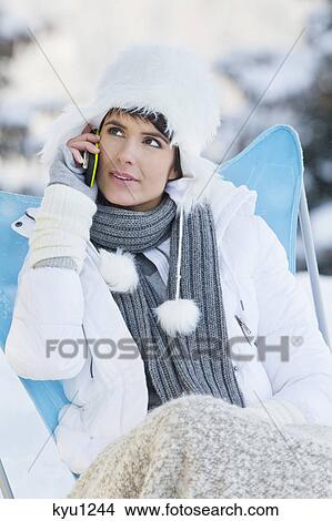 Young woman using mobile phone in snow View Large Photo Image Picture - Young woman using mobile phone in snow. Fotosearch