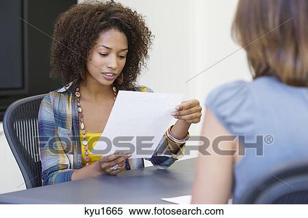 African American woman reading a resume while taking interview of a Caucasian woman View Large Photo Image Stock Photography - African American woman reading a resume while taking interview of a Caucasian woman. Fotosearch