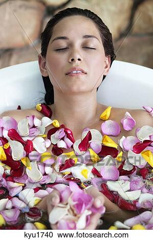 Beautiful young woman relaxing in bathtub with petals View Large Photo Image Stock Image - Beautiful young woman relaxing in bathtub with petals. Fotosearch