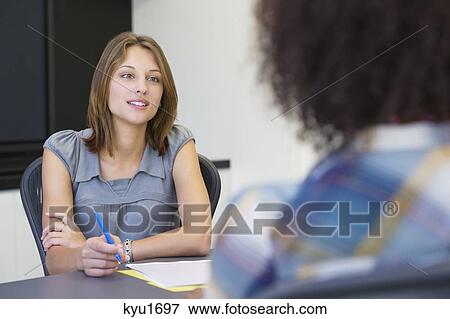 Businesswoman taking an interview of an African American woman View Large Photo Image Stock Photo - Businesswoman taking an interview of an African American woman. Fotosearch
