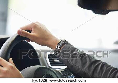 Close-up of a human hand on car steering wheel View Large Photo Image Stock Photo - Close-up of a human hand on car steering wheel. Fotosearch