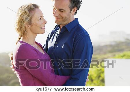 Stock Photo - Close-up of a mid adult couple embracing each other. Fotosearch