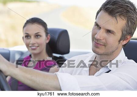 Couple driving a convertible car View Large Photo Image Stock Image - Couple driving a convertible car. Fotosearch