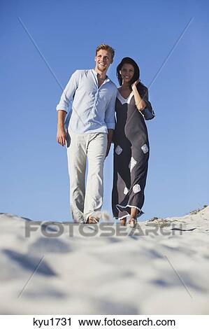 Couple walking on the beach View Large Photo Image Stock Image - Couple walking on the beach. Fotosearch