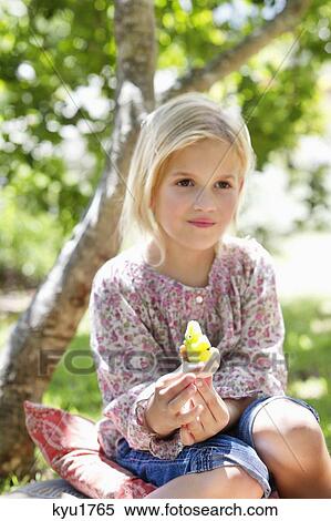 Cute little girl holding a toy outdoors View Large Photo Image Stock Photography - Cute little girl holding a toy outdoors. Fotosearch