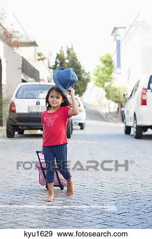 Cute little girl walking with luggage View Large Photo Image Stock Photo - Cute little girl walking with luggage. Fotosearch