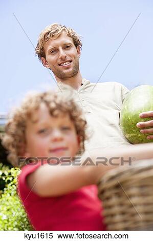 Father and son holding fruits View Large Photo Image Stock Photography - Father and son holding fruits. Fotosearch