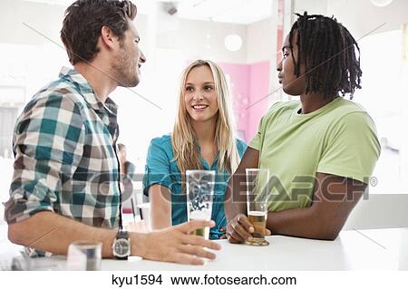 Picture - Friends having beer at a bar. Fotosearch