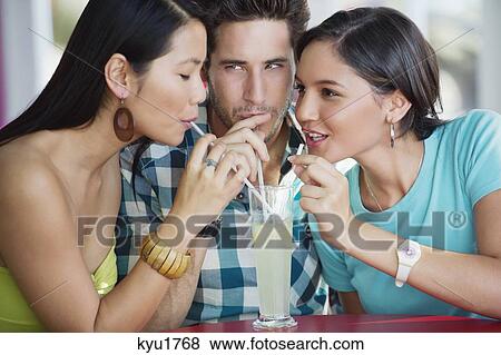 Stock Photo - Friends sharing lime juice in a restaurant. Fotosearch
