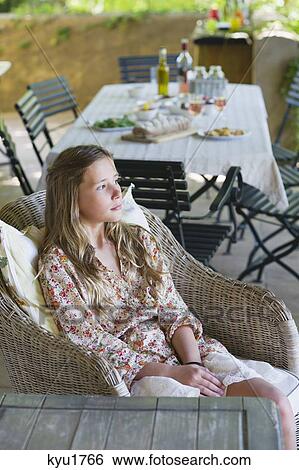 Little girl looking away with food on table in the background View Large Photo Image Stock Photograph - Little girl looking away with food on table in the background. Fotosearch