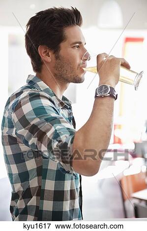 Man drinking beer at a bar View Large Photo Image Stock Photo - Man drinking beer at a bar. Fotosearch