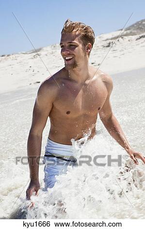 Stock Photograph - Man enjoying on a beach. Fotosearch