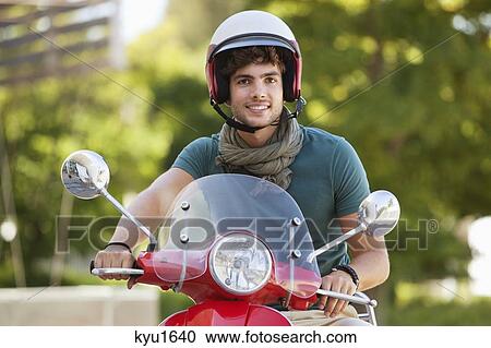 Stock Image - Man riding a scooter. Fotosearch