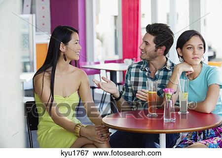 Man talking to a woman while their friend looking away View Large Photo Image Stock Photo - Man talking to a woman while their friend looking away. Fotosearch