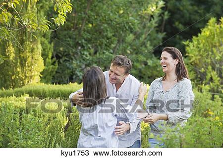 Mature couple hugging their mother in a garden View Large Photo Image Stock Image - Mature couple hugging their mother in a garden. Fotosearch