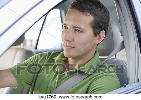 Mid adult man driving a car View Large Photo Image Stock Image - Mid adult man driving a car. Fotosearch