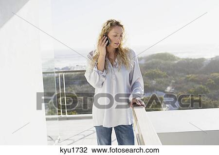 Stock Image - Mid adult woman talking on a mobile phone. Fotosearch