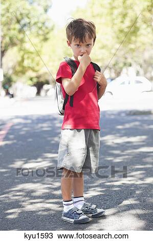 Portrait of a cute little boy standing with finger in mouth View Large Photo Image Stock Image - Portrait of a cute little boy standing with finger in mouth. Fotosearch
