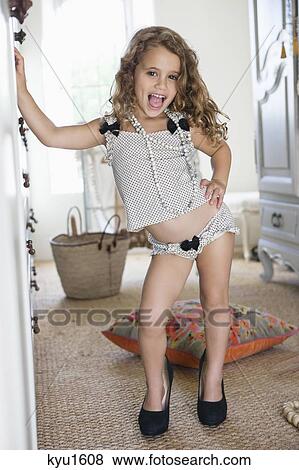 Portrait of a little girl dressed like her mother in oversized accessories View Large Photo Image Stock Photo - Portrait of a little girl dressed like her mother in oversized accessories. Fotosearch