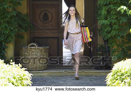 Picture - Portrait of a little girl walking out of her home. Fotosearch