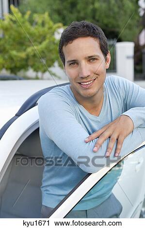 Portrait of a mid adult man leaning at open car door View Large Photo Image Stock Image - Portrait of a mid adult man leaning at open car door. Fotosearch