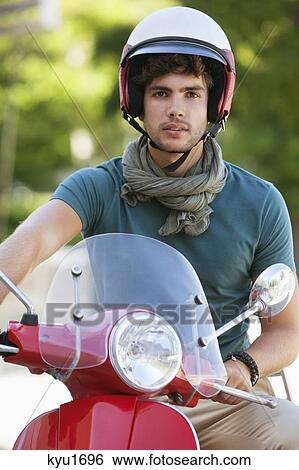 Portrait of a young man sitting on a motor scooter View Large Photo Image Stock Photograph - Portrait of a young man sitting on a motor scooter. Fotosearch