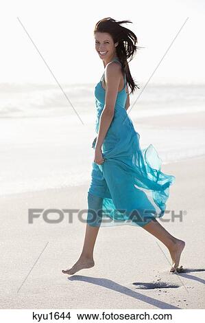 Portrait of a young woman walking on beach View Large Photo Image Picture - Portrait of a young woman walking on beach. Fotosearch