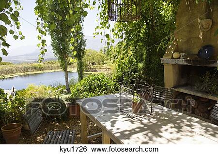 Stock Photograph - Potted plant on a table in a veranda. Fotosearch