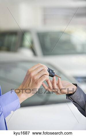 Salesman handing car key to woman View Large Photo Image Stock Photo - Salesman handing car key to woman. Fotosearch
