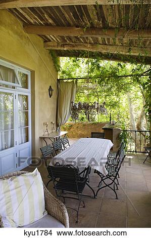 Table and chairs in a veranda View Large Photo Image Picture - Table and chairs in a veranda. Fotosearch