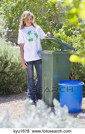 Stock Photo - Woman looking into recycling bin. Fotosearch